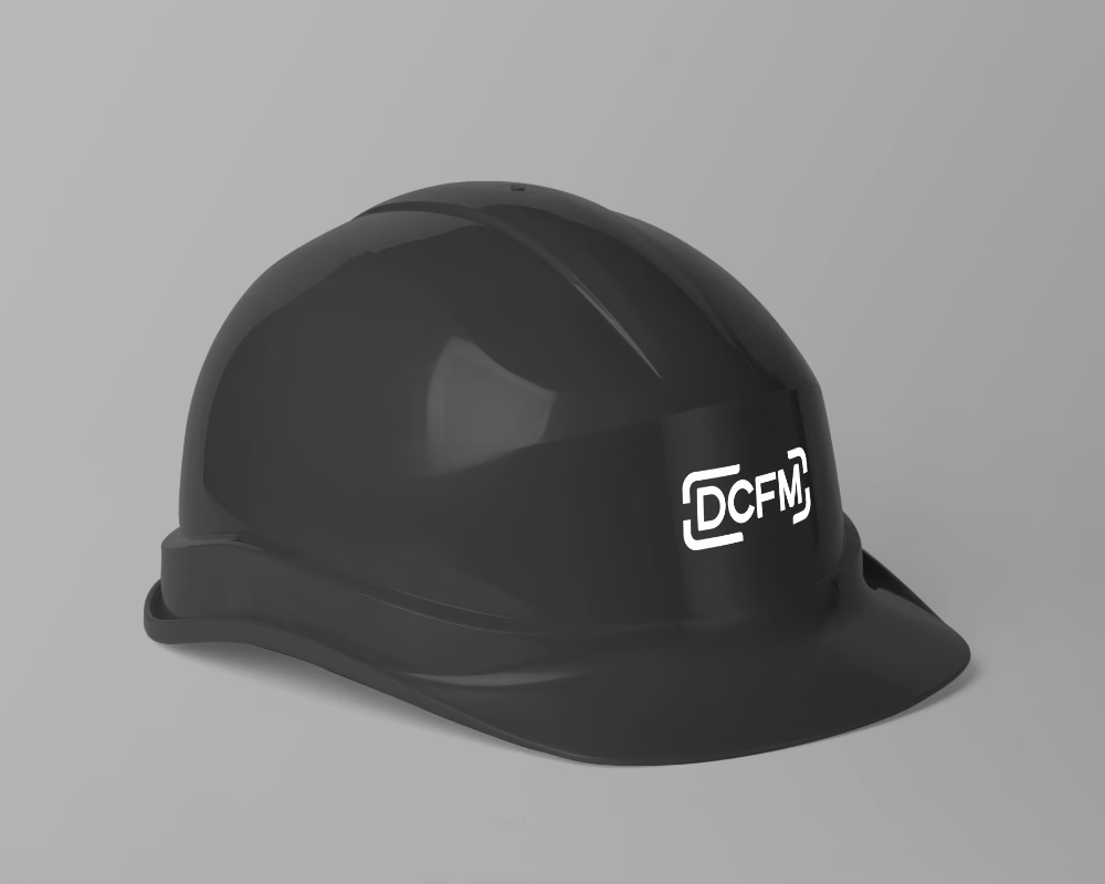 DCFM logo concept applied to black construction safety helmet